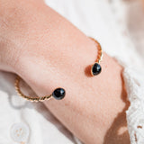Gros plan sur le cabochon onyx du bracelet jonc Paul plaqué or